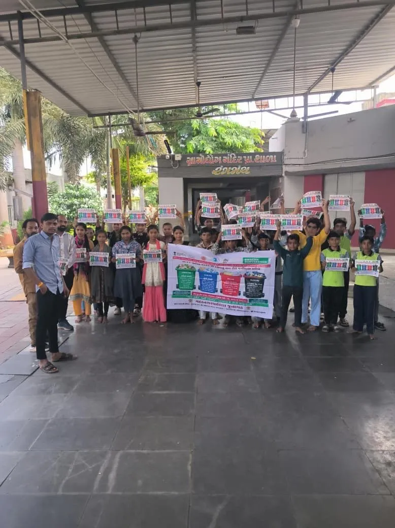 Students and sanitation staff in high-visibility vests walking with banners during a cleanliness awareness rally