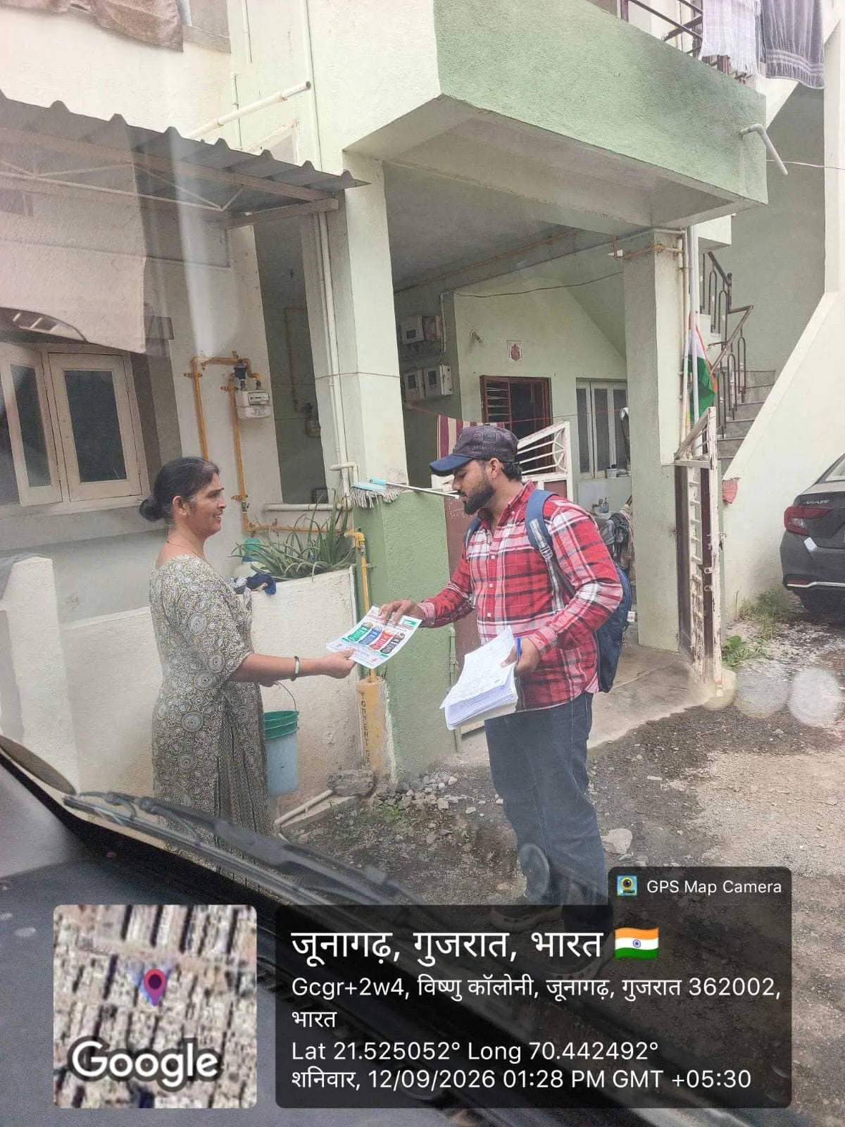 A J Kachrewala worker handing segregation awareness material to a resident at their doorstep in Junagadh