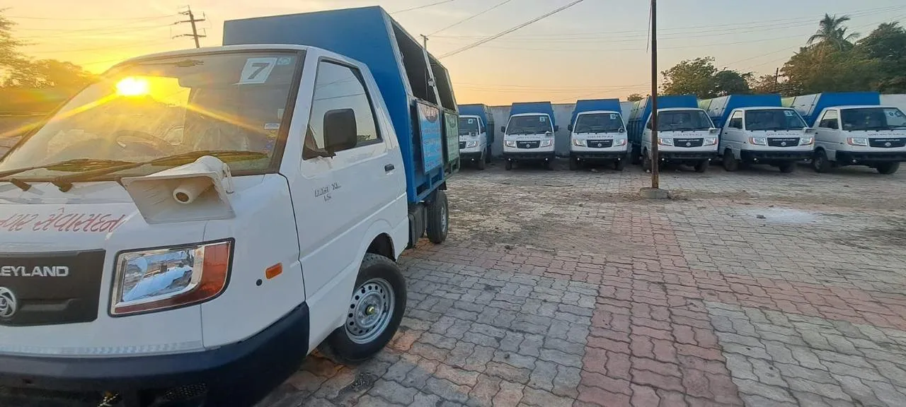 A row of J Kachrewala collection vehicles lined up at sunrise before deployment